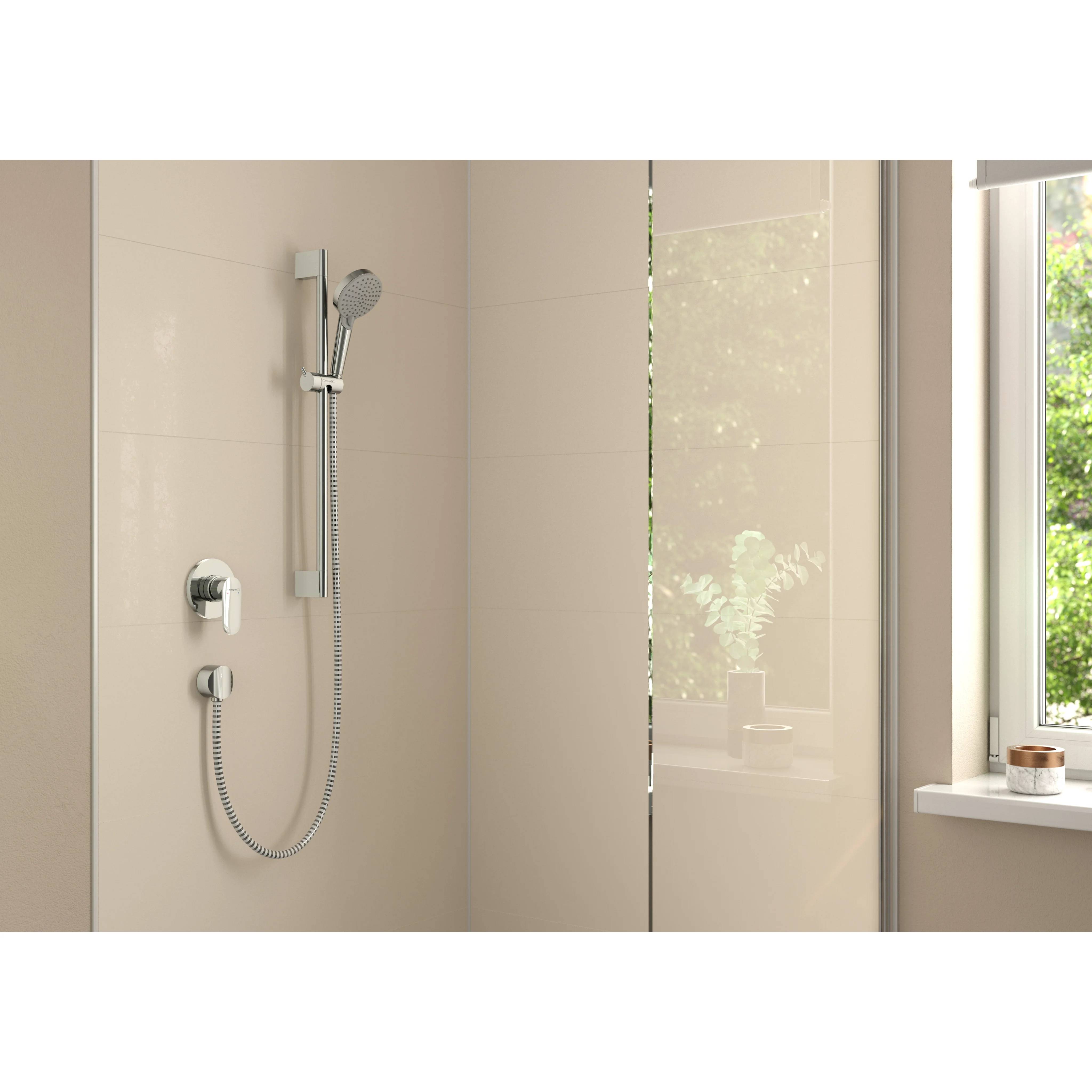 Modernes beiges Badezimmer mit einer wandmontierten Handbrausestange und Schlauch neben einer Glastrennwand und einem Fenster.