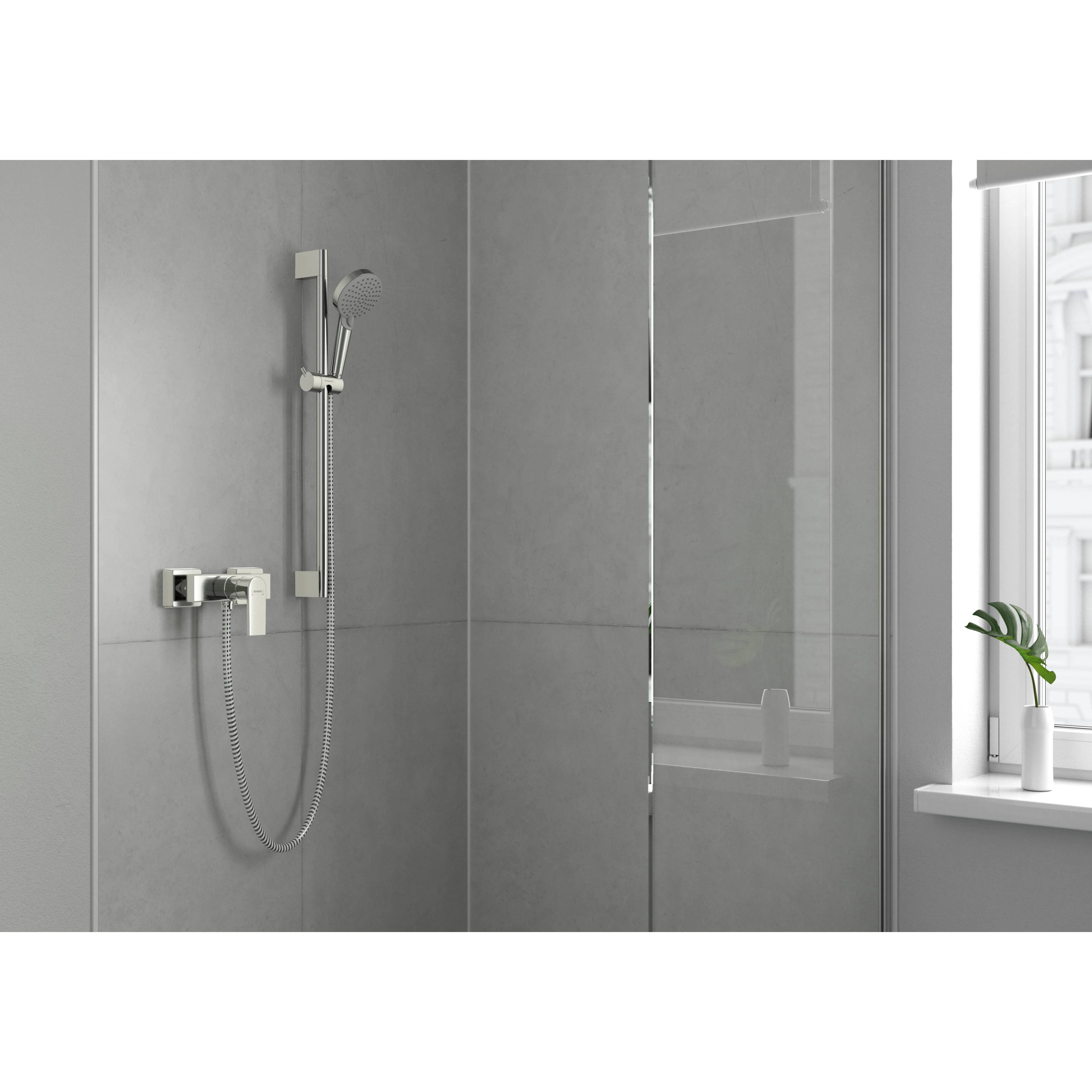 Modernes Badezimmerinterior mit an der Wand montiertem Duschkopf aus Chrom und tragbarem Sprühkopf neben einer Glasduschabtrennung und einem Fenster