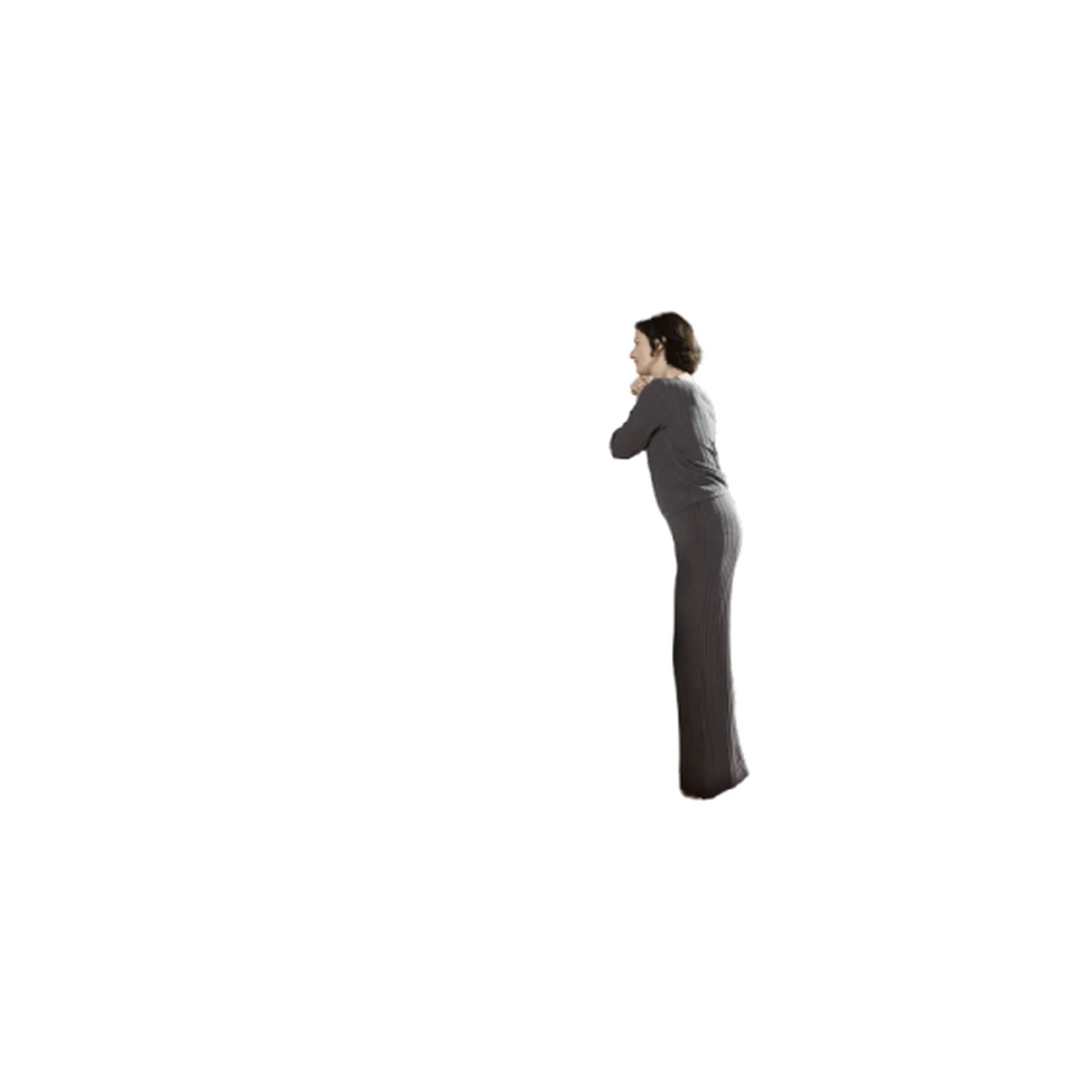 Seitenansicht einer Frau, die allein im Profil steht, trägt ein langes dunkles Kleid vor einem einfachen weißen Hintergrund.