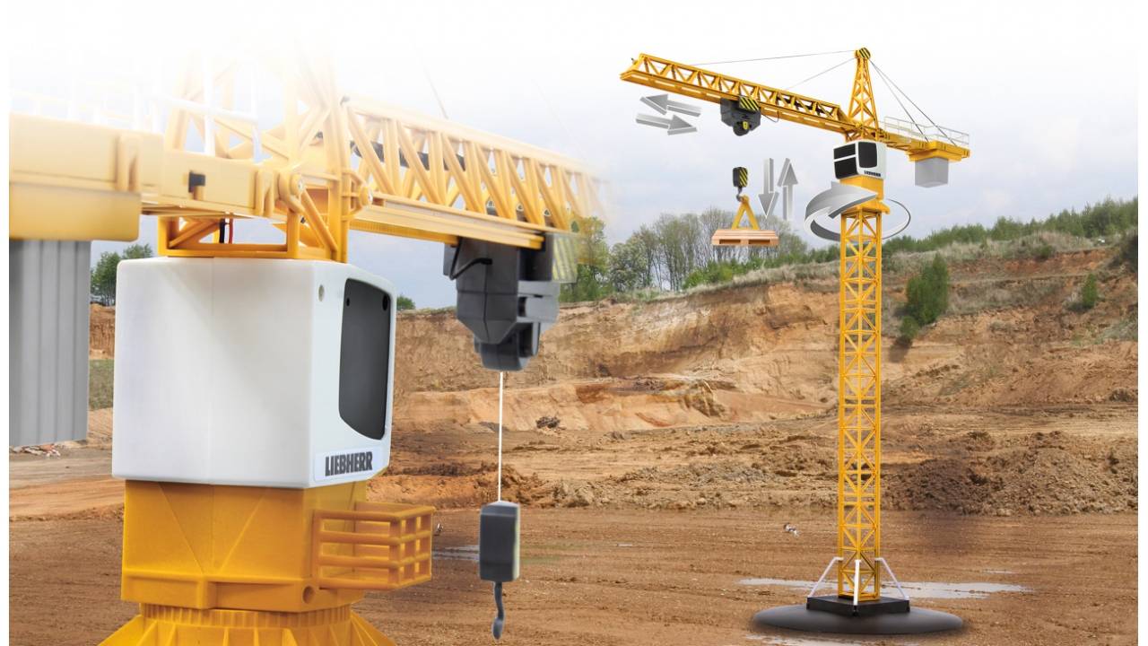 Ein gelber Liebherr-Turmkran auf einer Baustelle hebt eine schwere Last, mit einem weiteren Kran und einer sandigen Aushubgrube im Hintergrund.