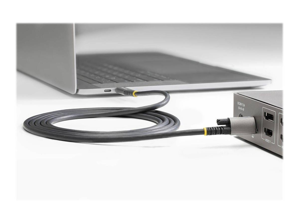 Ethernet-Kabel verbunden zwischen einem Laptop und einem kleinen Netzwerkgerät auf weißem Hintergrund.
