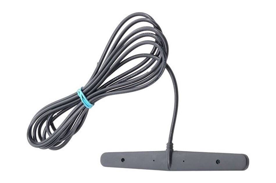 Ein langes schwarzes Kabel, das sich um sich selbst windet, befestigt an einem flachen schwarzen Gerät mit einem kurzen Draht, der sich daraus erstreckt, möglicherweise eine Antenne.