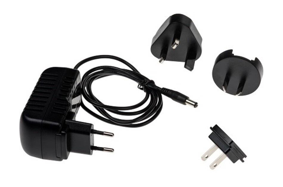 Schwarzer Stromadapter mit Kabel und austauschbaren internationalen Steckern auf weißem Hintergrund