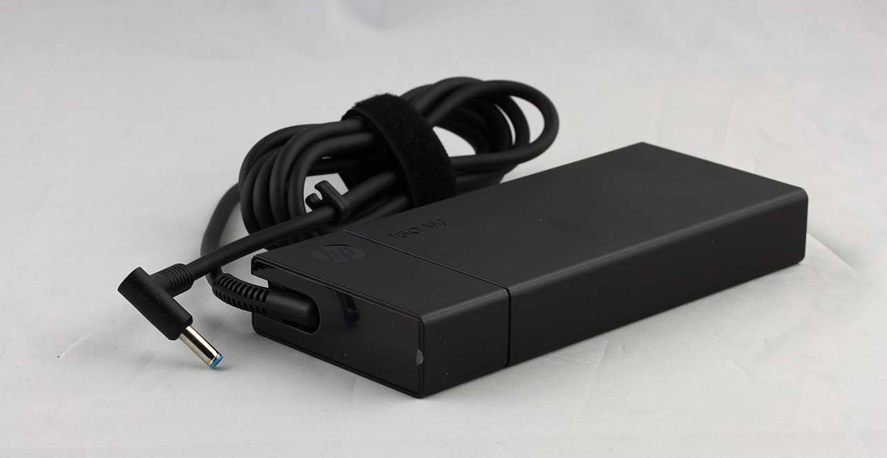 Schwarzer Laptop-Stromadapter mit Spiralkabel und Winkelstecker auf weißem Hintergrund.