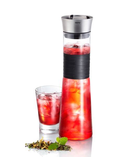 Hohes Glaskännchen und Becher gefüllt mit rotem Eisbeverage, mit Minzgarnitur, freigestellt auf weißem Hintergrund.