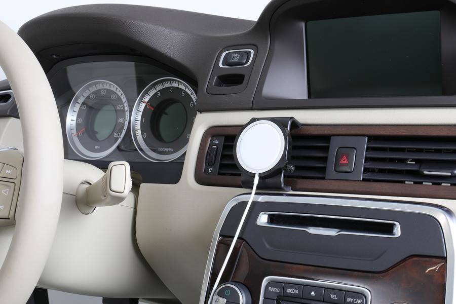 Autoinnenraum-Dashboard mit Lenkrad, Instrumenten, Mittelkonsolen-Display und einem auf der Lüftungsgitter montierten Telefon.