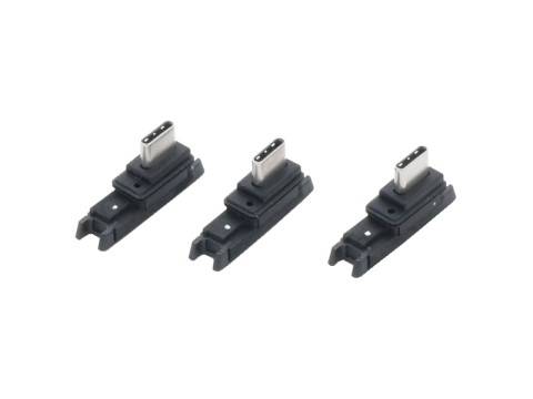 Drei kleine schwarze USB-C-Ladegeräte oder Stecker diagonal auf weißem Hintergrund angeordnet.