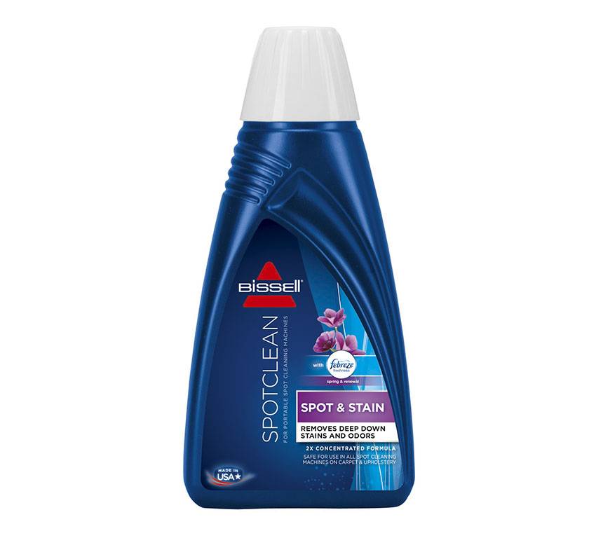 Blaue Bissell SpotClean Fleck- und Fleckenentferner-Flasche für Teppiche mit Blumenduft-Etikett auf weißem Hintergrund.