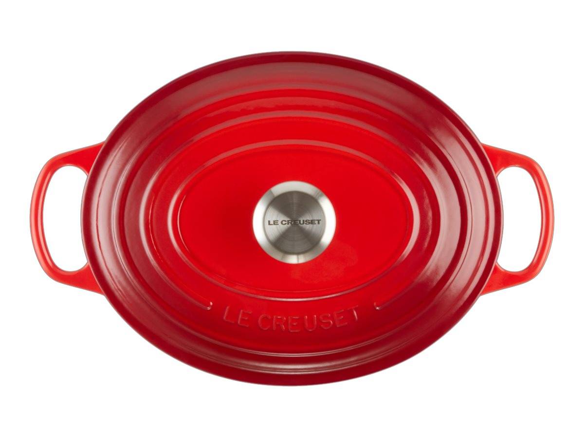 Rote ovale Le Creuset Bratentopf mit Deckel und zwei Griffen, von oben auf weißem Hintergrund gezeigt.