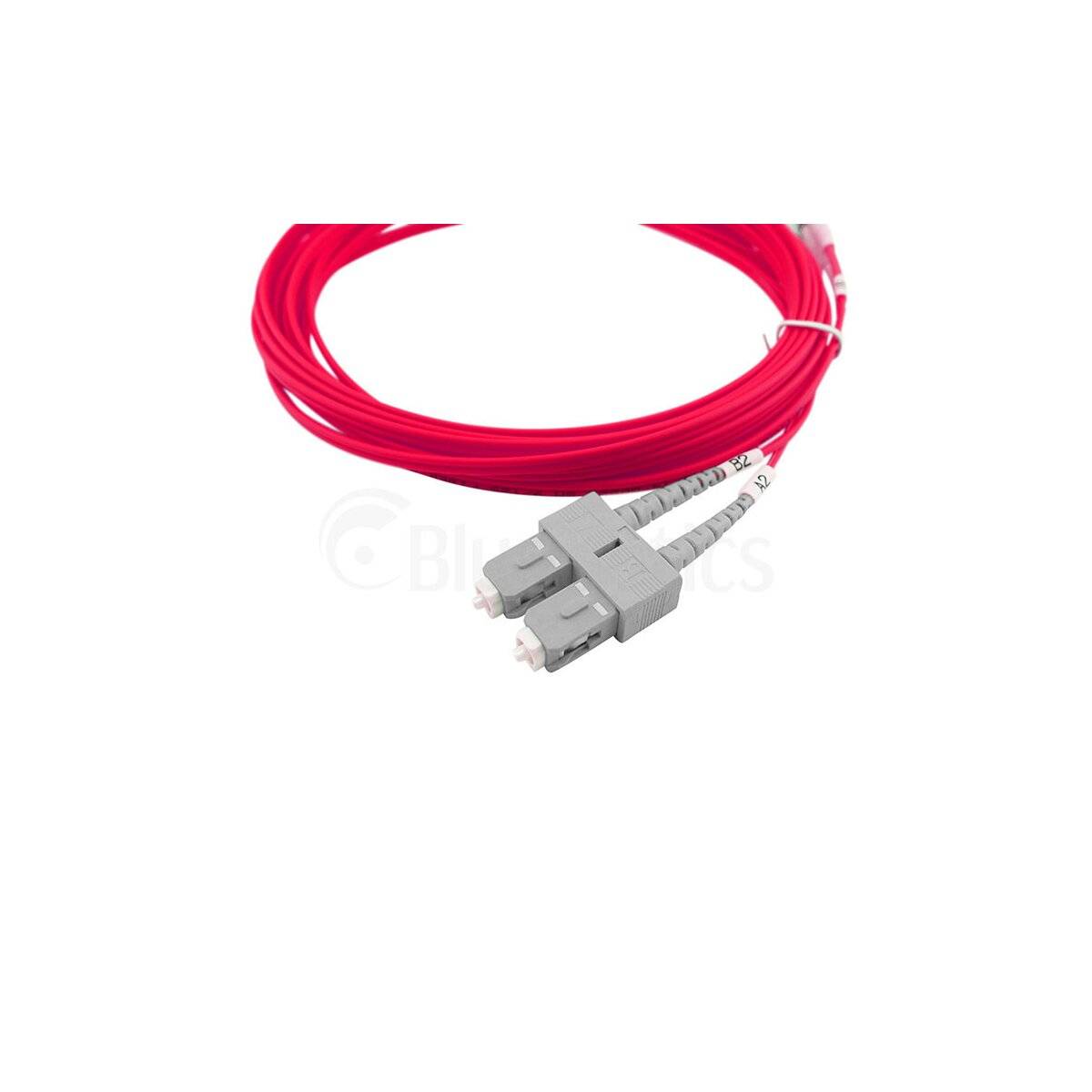 Aufgewickeltes rotes Lichtwellenleiterkabel mit grauen Steckverbindern auf weißem Hintergrund.