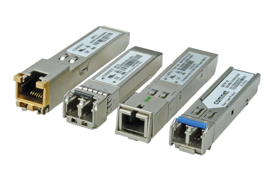 Vier kleine netzwerktransceiver-Module zum Einstecken auf weißem Untergrund mit Metallgehäusen und Glasfaser-/Ethernet-Anschlüssen.