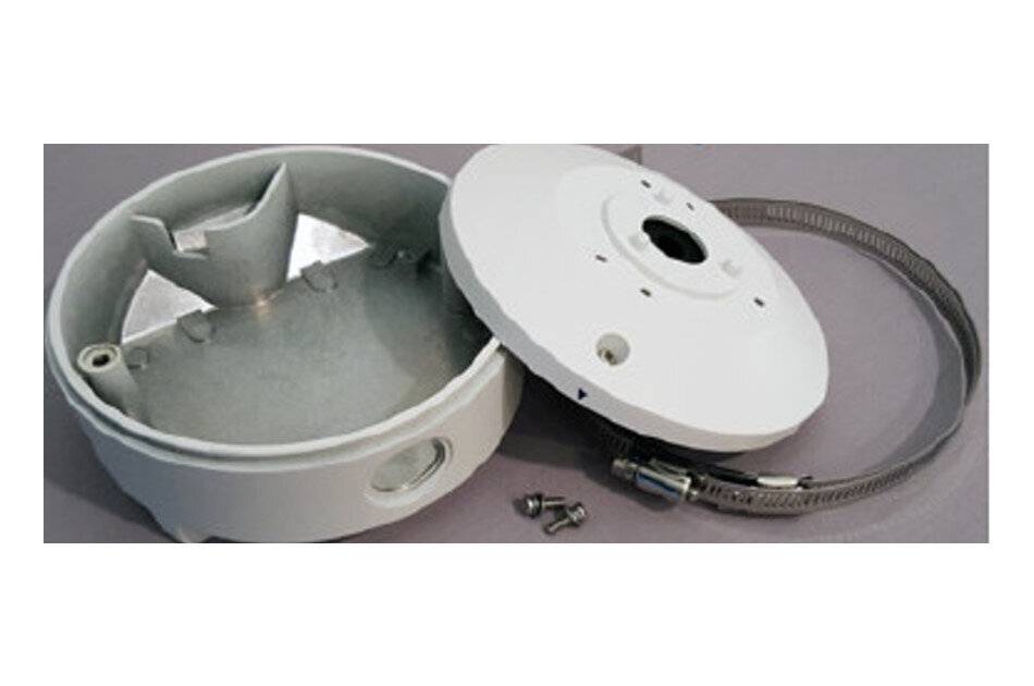 Eine demontierte weiße Sicherheitskamera-Halterung mit ihrem Deckel, zwei Schrauben und einer Metallklemme auf einer grauen Oberfläche.