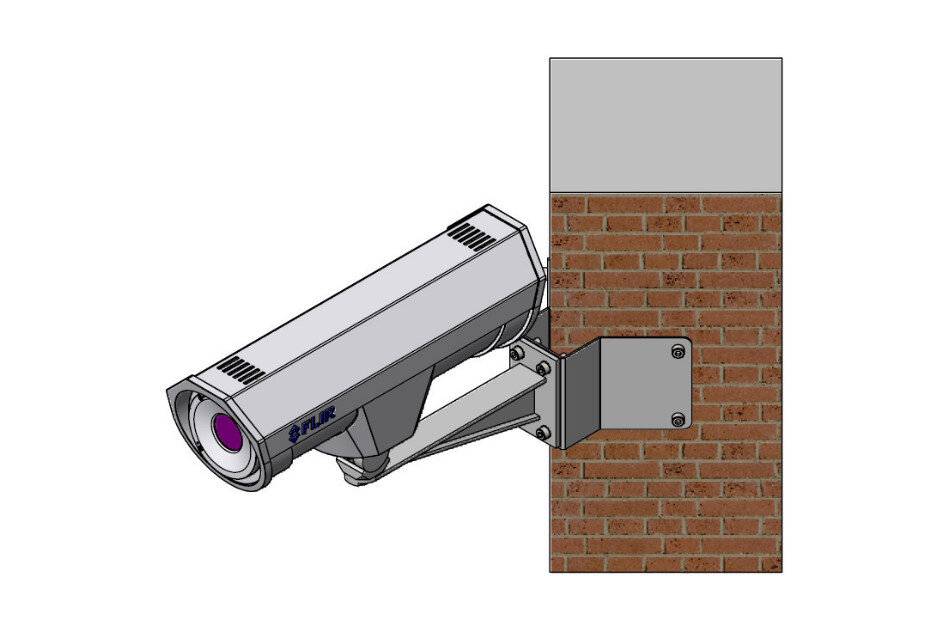 An der Wand montierte Sicherheitskamera, nach unten ausgerichtet, an einer Ziegelmauer mit einer grauen Halterung befestigt.