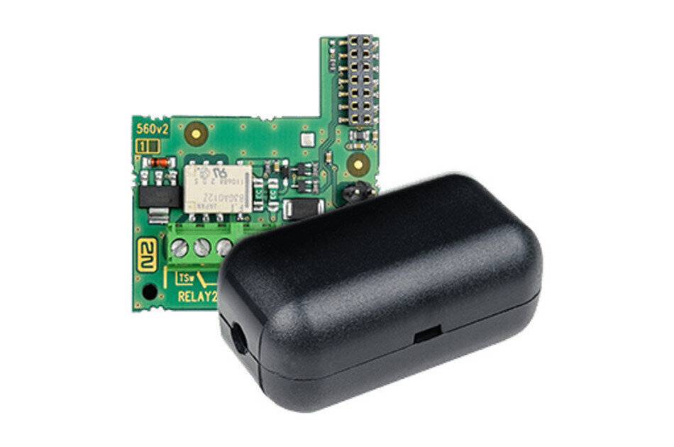 „Eine kleine grüne Leiterplatte mit mehreren elektronischen Komponenten, einschließlich eines Relais, neben einem schwarzen Kunststoffgehäuse. Die Platine ist mit „RELAY2