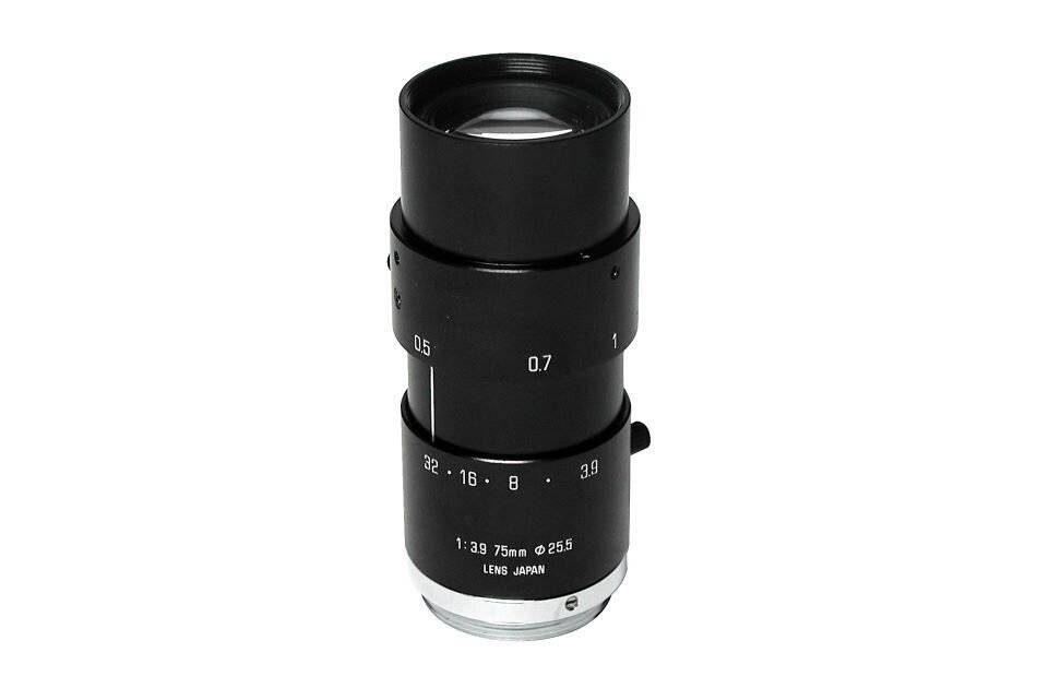 Eine schwarze Kameraobjektiv mit Brennweitenmarkierungen, '1:3,9 75mm @ 25,5', hergestellt in Japan, aufrecht gegen einen einfarbigen Hintergrund positioniert.