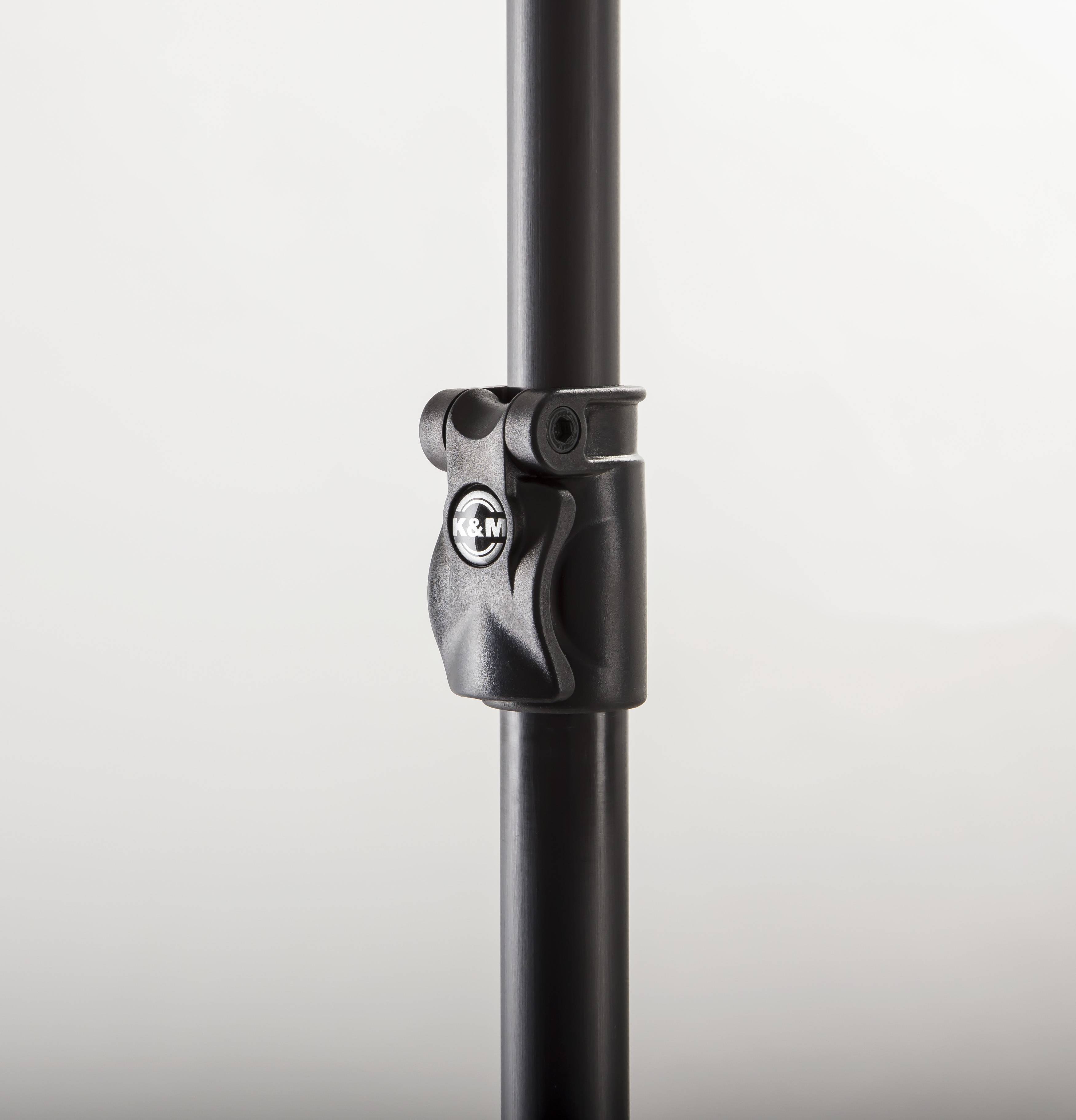 Schwarzer Mikrofonständer-Klemme mit K&M-Logo, befestigt an einer vertikalen Stange auf einfachem hellem Hintergrund.