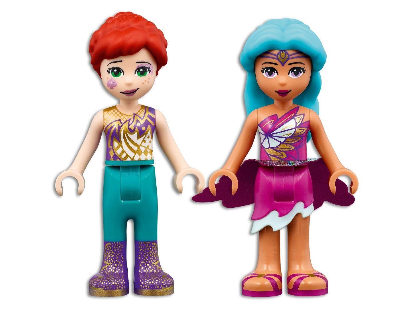 Zwei LEGO-ähnliche Minipuppen stehen nebeneinander: ein rothaariger Junge in türkisfarbener Hose und ein Mädchen mit türkisfarbenem Haar in einem rosa-violetten Kleid, beide in fantasievollen Outfits gekleidet.
