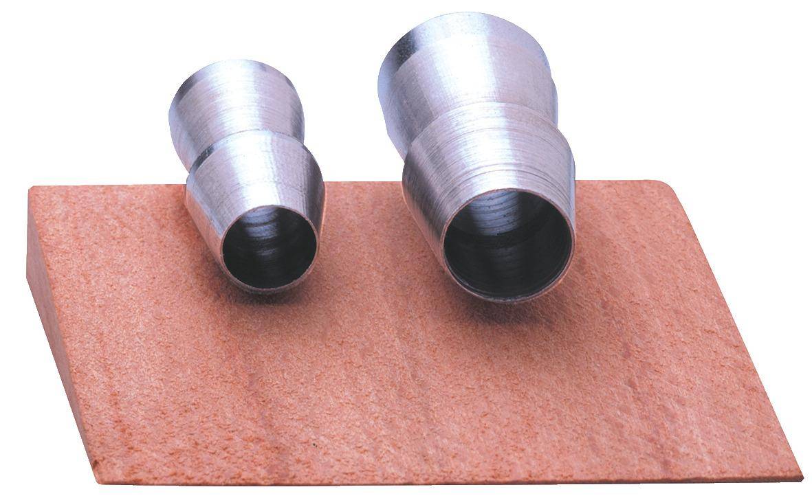 Zwei Metallrohrverbindungen auf einer strukturierten braunen Oberfläche; die linke Verbindung ist kleiner als die rechte.