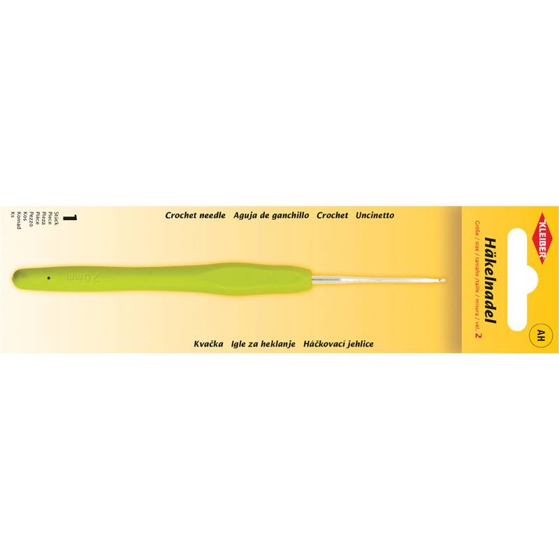 Verpackte grüne Häkelnadel mit Beschriftung in mehreren Sprachen: „Häkelnadel, Aguja de ganchillo, Crochet, Uncinetto
