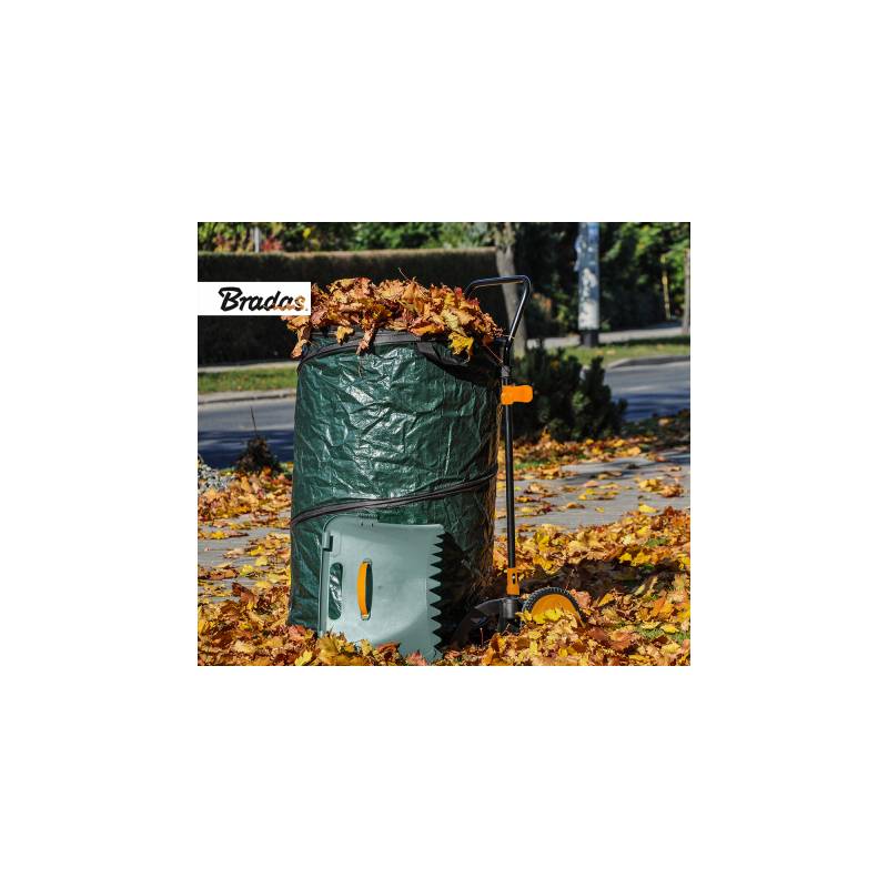 Herbstlaub-Sack, der auf einem Rasen mit herumliegenden Blättern gefüllt ist, mit einer Harke und einem Laubsammler in der Nähe.