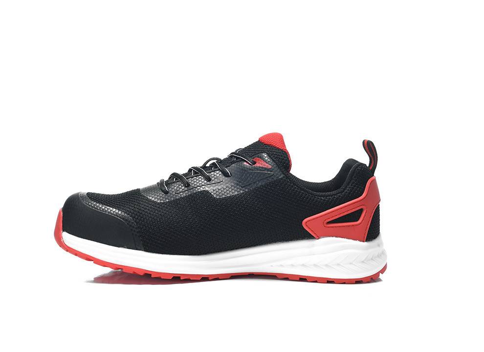 Ein schwarzer und roter Sportschuh mit einer strukturierten schwarzen Oberfläche, roten Akzenten und einer weißen Sohle, der in Seitenansicht vor einem weißen Hintergrund gezeigt wird.
