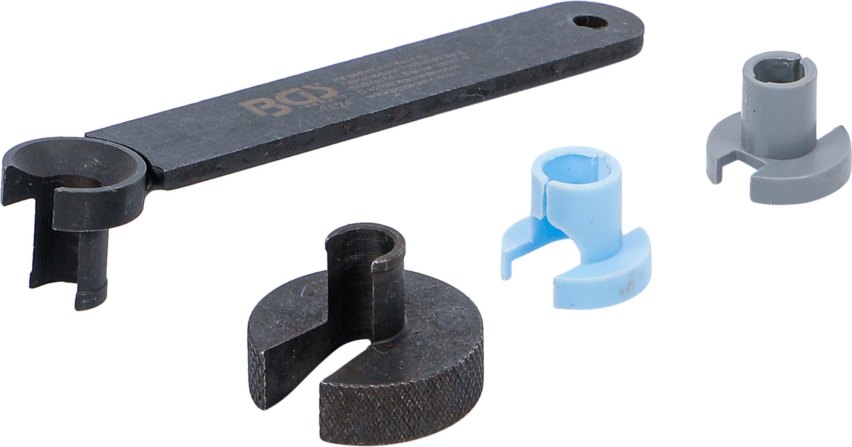 Ein flaches Metallinstrument mit einem Loch an einem Ende liegt neben zwei kreisförmigen Komponenten: einer schwarzen mit einem Ausschnitt und einer blauen mit offener Oberseite.