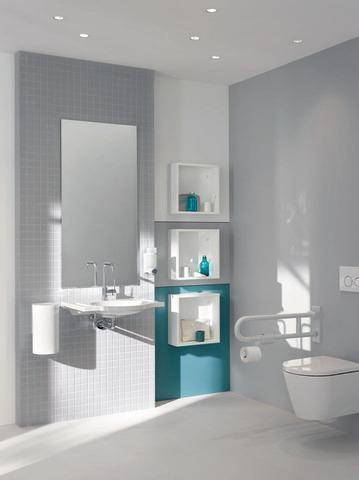 Modernes Badezimmer mit einer Grau-Weiß-Farbpalette. Ausgestattet mit einem wandmontiertem Waschbecken, Spiegel, Ablagregalen mit Toilettenartikeln und einem Haltegriff.
