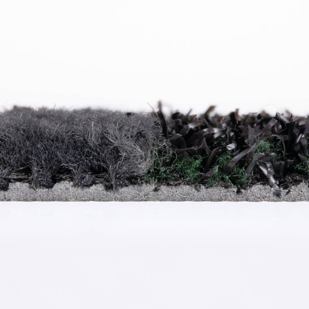 Eine Nahaufnahme von zwei kontrastierenden rasenähnlichen Materialien: graue, dünne Strähnen auf der linken Seite und dunkel gekräuselte Streifen mit einigen grünen Flecken auf der rechten Seite.