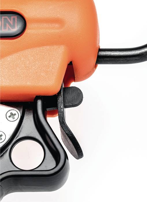 Nahaufnahme eines orange und schwarzen Maschinenteils, die einen Hebel und metallische Komponenten zeigt, was auf industrielle oder mechanische Ausrüstungsverwendung hindeutet.