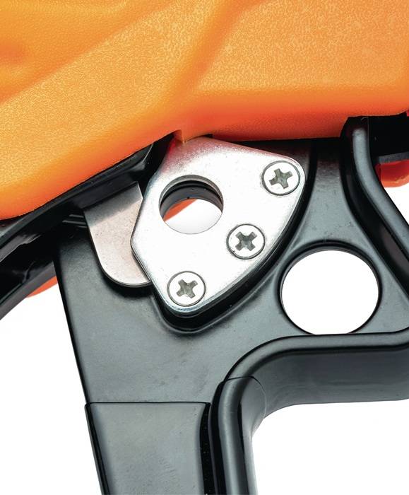 Nahaufnahme eines mechanischen Auslösemechanismus mit schwarzen, silbernen und orangefarbenen Komponenten, die Schrauben und eine strukturierte Oberfläche zeigt.