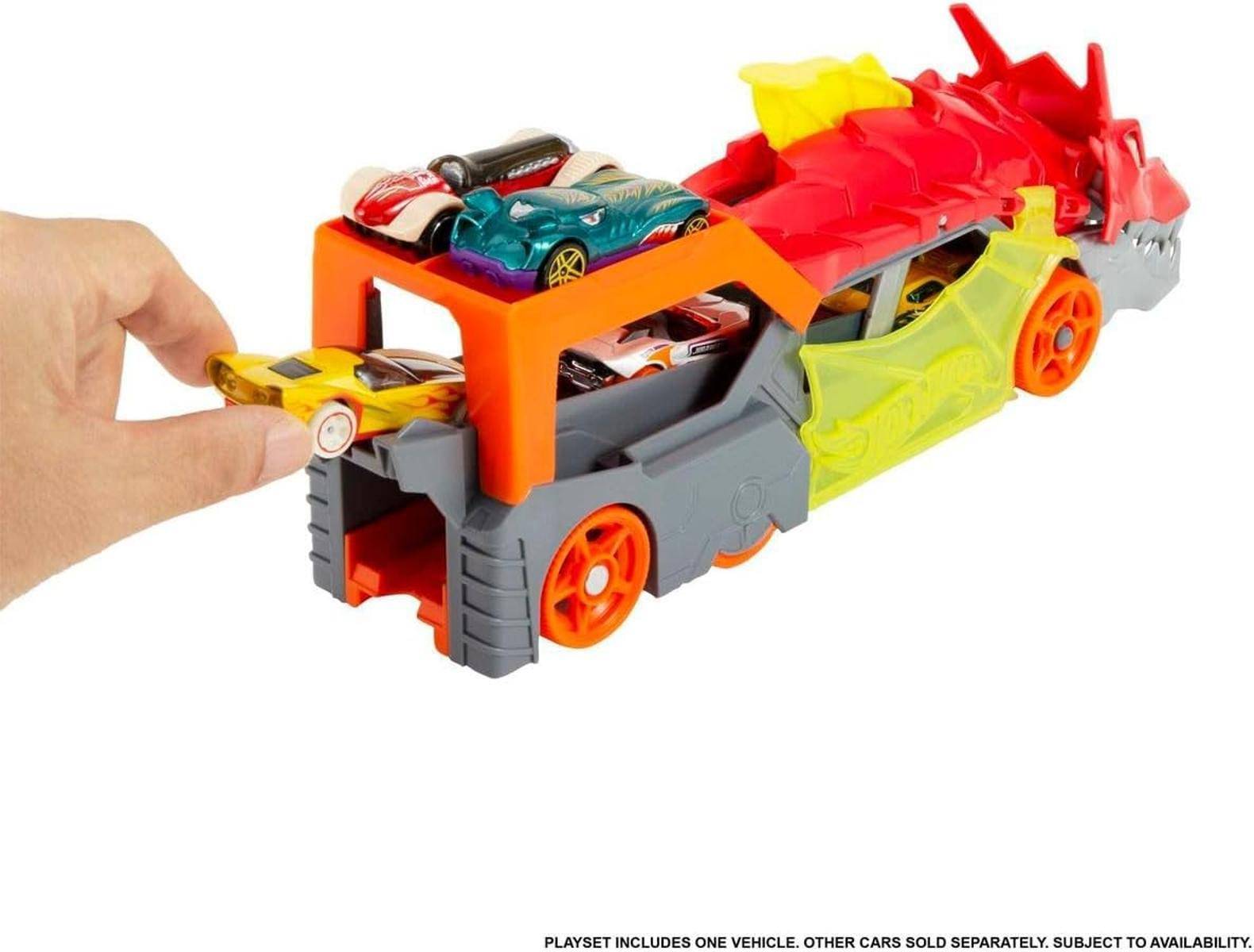 Spielzeug-Dinosaurier-Lastwagen mit einer Hand, die ein kleines gelbes Auto in die Ladefläche lädt, mit anderen Spielzeugautos oben drauf und innen.
