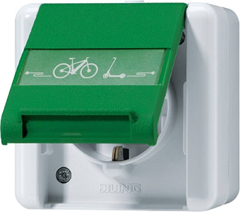 Eine weiße Steckdose mit einem grünen Deckel, die Symbole eines Fahrrads und eines Rollers zeigt und darauf hinweist, dass sie zum Aufladen dieser Fahrzeuge dient.