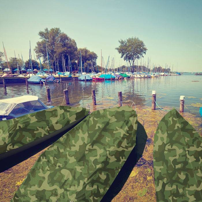 Eine ruhige Seenlandschaft mit mehreren Booten in Tarnabdeckungen, Bäumen, die das Ufer säumen, und klarem blauem Himmel, der sich im ruhigen Wasser spiegelt.