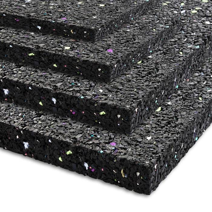 Übereinander gestapelte Schichten schwarzer Gummimatten mit mehrfarbigen Sprenkeln, die zur Schalldämmung und Polsterung von Böden verwendet werden.