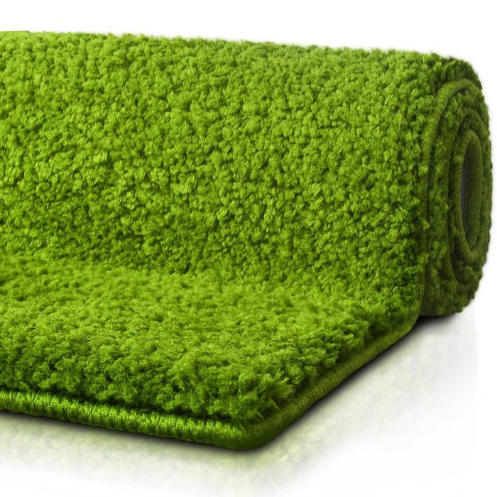 Ein aufgerollter grüner Teppich mit flauschiger Textur, der seine Dicke und lebendige Farbe zeigt. Der Teppich bedeckt den Großteil des Bildes.