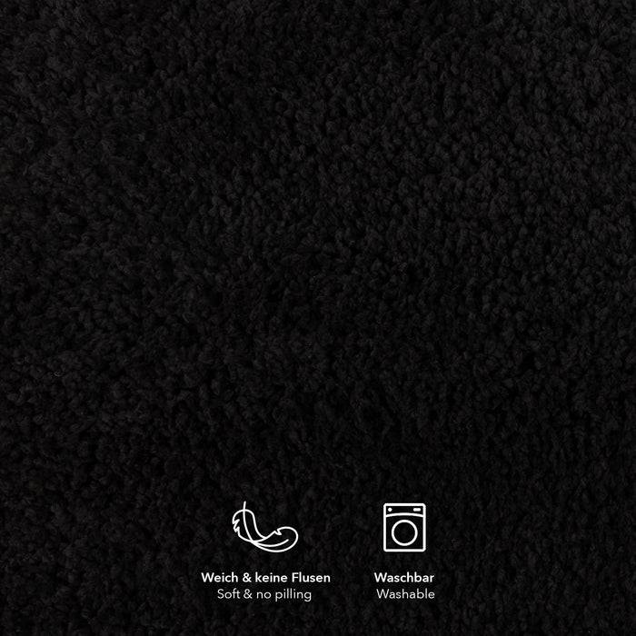 Eine Nahaufnahme einer schwarzen texturierten Oberfläche mit kleinen Symbolen darunter, die „weich & fusselfrei