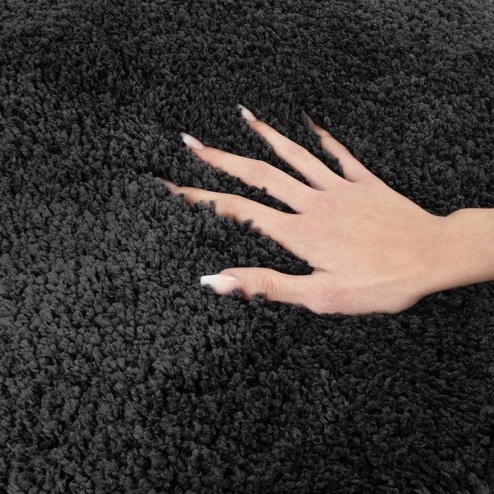 Eine Hand liegt ausgebreitet auf einem strukturierten grauen Teppich und betont dessen weiche und üppige Oberfläche.