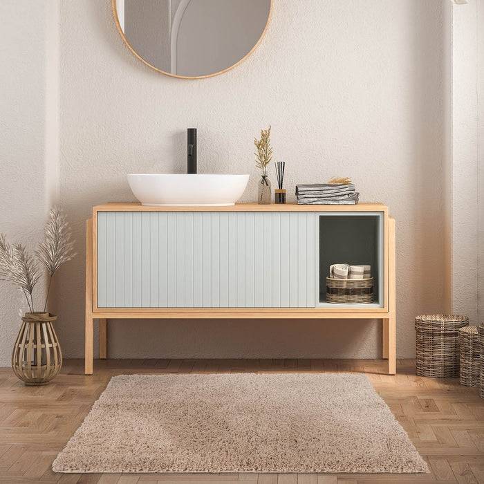 Eine helle Holz-Waschtischkonsole mit einem weißen Waschbecken, rundem Spiegel und minimalistischer Dekoration in einer stilvollen Badezimmerumgebung.