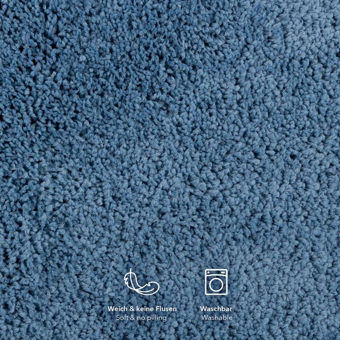 Blaues strukturiertes Gewebe mit Icons einer Feder und einer Waschmaschine. Text liest sich „Weich & keine Flusen