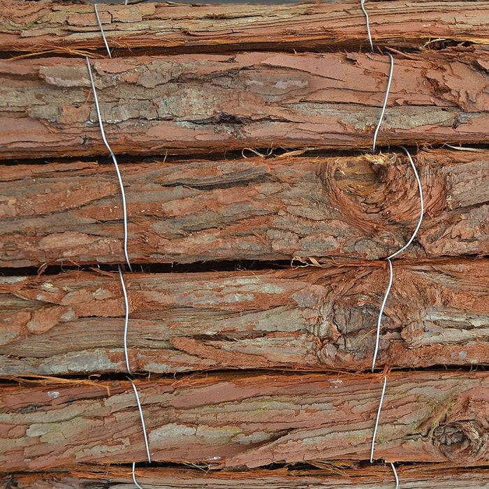 Ein Nahaufnahmebild von gestapelten Holzstämmen, die mit Metalldraht gebunden sind und eine raue Rindenstruktur und horizontale Ausrichtung zeigen.