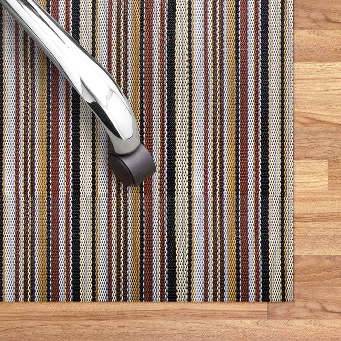 Bürostuhl mit Chromgestell, positioniert auf einem gestreiften Teppich mit braunen, blauen und beigen Farben. Der Boden ist aus Holz.