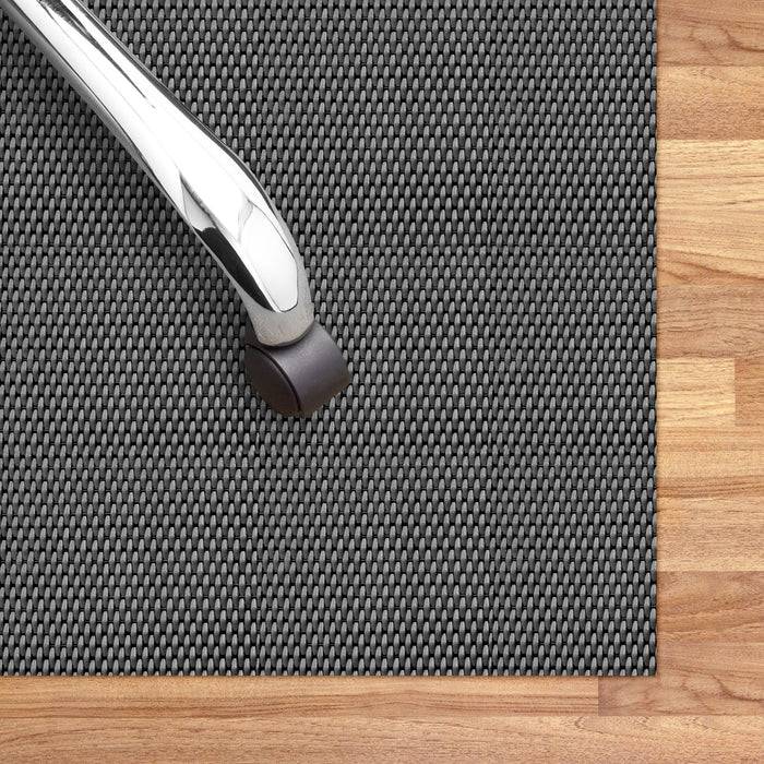 Bürostuhlrolle auf einer schwarzen Bodenmatte, die auf einem Holzboden platziert ist.