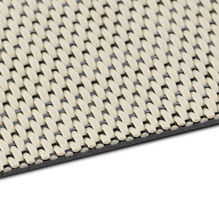 Nahaufnahme eines strukturierten, gewebten beige- und schwarzfarbigen Stoffs, der ein verschlungenes Muster zeigt.