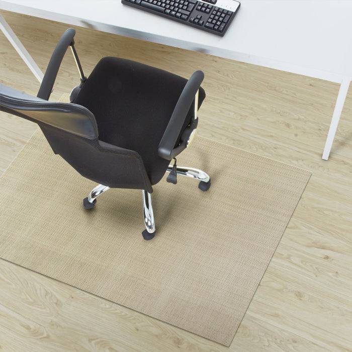 Bürostuhl auf einer beigefarbenen Matte, von oben betrachtet, neben einem weißen Schreibtisch mit einer schwarzen Tastatur.