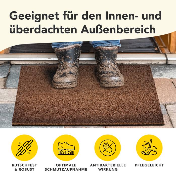 # Eine Person mit verschmutzten Stiefeln tritt auf eine braune Fußmatte. Der Text oben lautet: „Geeignet für den Innen- und überdachten Außenbereich