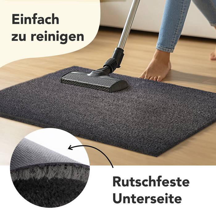 Leicht zu reinigen, rutschfeste Unterseite.' Eine Person wischt einen dunklen Teppich auf einem Holzboden, wobei die einfache Reinigung und die rutschfeste Unterseite hervorgehoben werden.