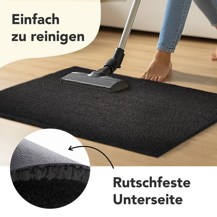 Eine Person, die einen schwarzen Teppich mit einem Staubsauger reinigt, wobei die Merkmale „Einfach zu reinigen