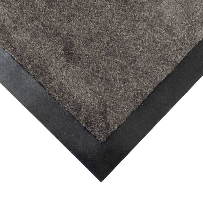 Nahaufnahme einer grauen strukturierten Bodenmatte mit schwarzem Rand, die das Eckendetail zeigt.