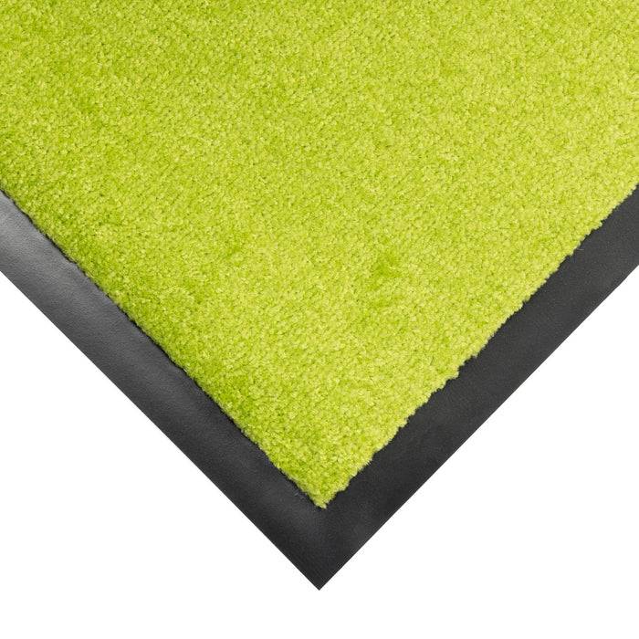 Ein lebendiger grüner Teppich mit einem kontrastierenden schwarzen Rand an einer Kante, der modernes Innendesign mit mutigen Farbwahl präsentiert.
