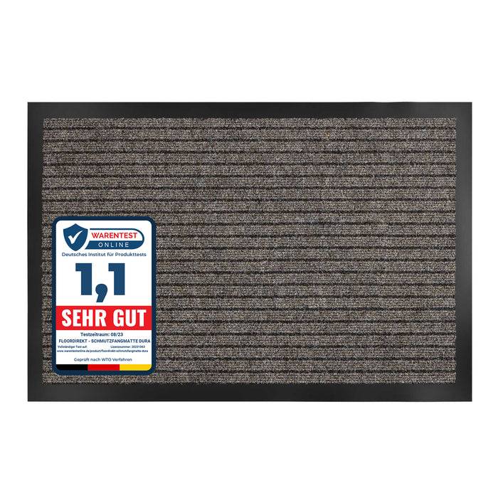 Fußmatte mit horizontal strukturierter Oberfläche und Bewertungsetikett, das '1,1 SEHR GUT' in Blau und Rot in der unteren linken Ecke zeigt.